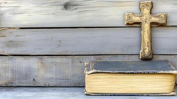A wooden background with space featuring a cross resting on an aged book, symbolizing faith and reflection photo