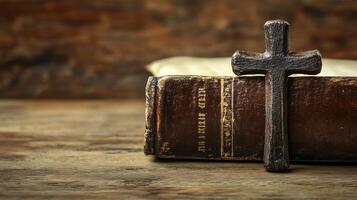 Decorative cross resting on a vintage book against a wooden background with ample space photo