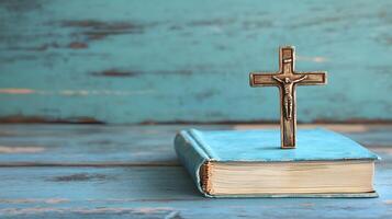 A cross resting on a book against a rustic wooden background with ample negative space photo