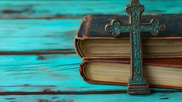 A decorative cross placed on top of vintage books resting on a wooden surface in tranquil setting photo