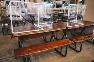 Group of plastic partition setting on table in canteen for reduce and protection the COVID-19 virus spreads in pandemic. Social distancing concept. photo