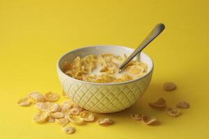 Bowl with muesli and milk on yellow background photo