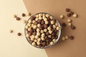 Bowl with corn balls on two tone background photo