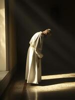 A priest in prayer kneels in a softly lit sanctuary, practicing reflection and devotion photo