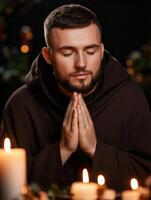 A priest in deep prayer surrounded by glowing candles in a tranquil setting at night photo