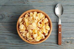 Spoon and bowl of muesli on wooden background photo