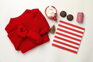Sweater, cup of coffee with marshmallow, cone, copybook, biscuits and string on white background photo