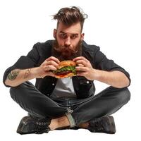 Bearded man sitting cross legged holding a hamburger photo