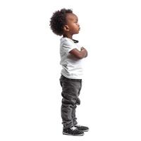 Side view of young boy standing and waiting with arms crossed photo