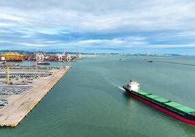 Aerial view of a large stock of new cars parked at a port terminal. Automotive industry logistics and transport operations. Import and export of vehicles by ship, with containers ready global trade. photo