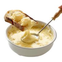 Person dipping bread in melted cheese fondue using a long fork photo