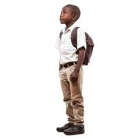 African schoolboy wearing uniform and backpack looking up photo