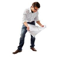 Focused architect studying blueprint plans on white background photo