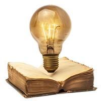 Vintage open book with glowing light bulb floating above photo