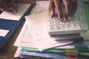 Hands of a man calculating his expenditure. photo