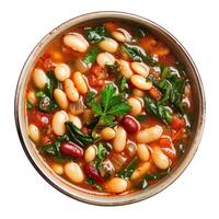Bean soup with tomatoes and greens in bowl, overhead view photo