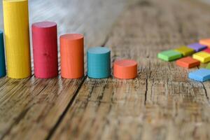 Colorful wooden toy blocks creating a bar chart on a rustic table photo