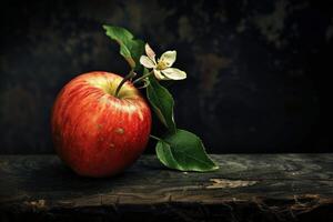 Red apple with flower resting on rustic wooden surface photo