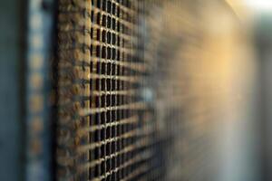 Metal grill with square pattern creating blurred background with warm light photo