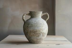 Ancient amphora standing on wooden table is showing the passage of time photo
