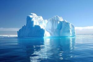 Huge iceberg is reflecting in calm ocean water under blue sky photo