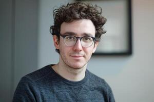 Young man with glasses smiling and posing for camera photo