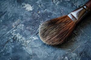 Large used makeup brush resting on gray countertop photo