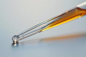Pipette releasing drop of liquid on a surface photo