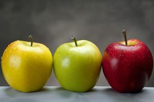 Three fresh apples standing on gray surface with dark background photo