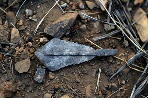 Ancient arrowhead laying on the ground at an archaeological dig photo