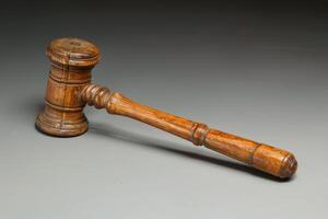 Wooden gavel lying on a gray surface symbolizing justice photo
