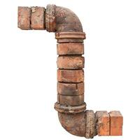 Old rusty drain pipe covered with bricks isolated on white background photo