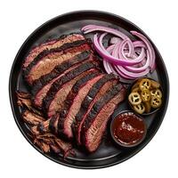 Smoked brisket slices with barbecue sauce and pickled jalapenos on black plate photo