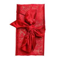 Elegant red gift wrapped in fabric with a bow on white background photo