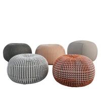 Trendy poufs with different colors and textures standing in a circle on white background photo