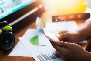 Hands of businesspeople using mobile phone and sending mail on working desk in office. photo