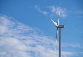 Wind turbines against blue sky, Wind energy. Wind power. Sustainable, renewable energy. Wind turbine generate electricity. Sustainable resources. Green technology for energy sustainability. photo