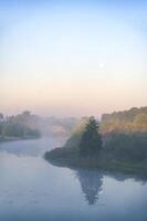 Tranquil misty morning landscape with serene river and soft pastel sky reflecting peaceful nature photo