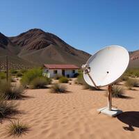 Satellite dish by desert home in barren setting photo
