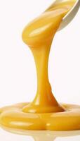 Melted cheese sauce spills onto a pristine white backdrop photo