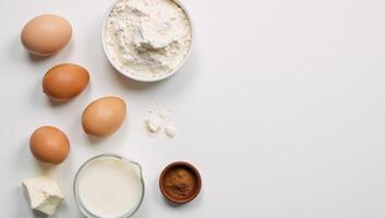 Topdown view Baking essentials eggs flour milk cottage cheese arranged against a textured white backdrop with ample room for copy photo