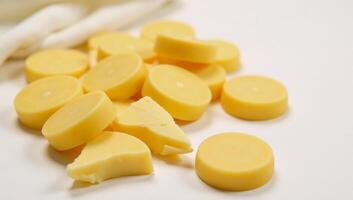 Deliciously arranged slice of cheese on a cool background with additional cheesy goodness on the table photo