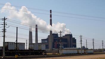 Factory with heavy power line pollution and smokestack emissions photo