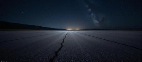 Abandoned nighttime scene featuring an empty asphalt surface beneath twinkling stars photo