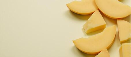 Deliciously arranged slice of cheese on a cool background with additional cheesy goodness on the table photo