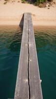 Abstract river scene water and natural elements depicted on an old wooden slab with a darkturquoise epoxy finish viewed from above over a sandy beach and riverbanks drone perspective photo
