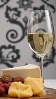 Closeup view of a white wine and cheese board on a stylishly designed backdrop photo