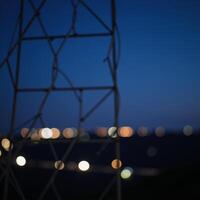 Striking abstract portrayal of energy and technology through electrifying nighttime scene of bokeh lighted power lines photo