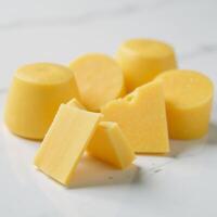Deliciously arranged slice of cheese on a cool background with additional cheesy goodness on the table photo