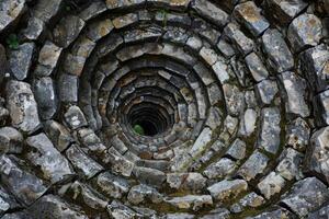 Ancient stone well showing concentric rings forming tunnel vision effect photo